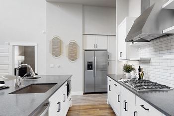 a kitchen with white cabinets and stainless steel appliances